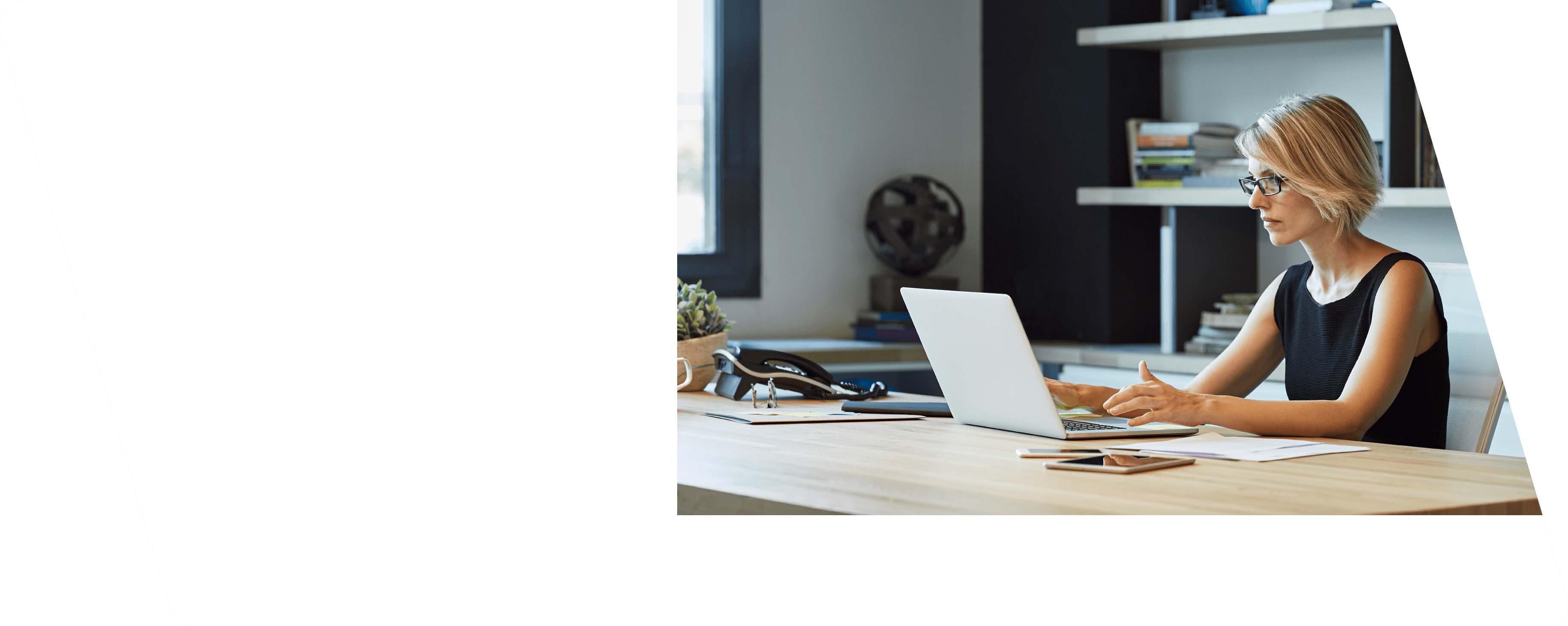 Businesswoman using laptop at desk. Confident female professional is working in textile factory. Executive is with short brown hair.