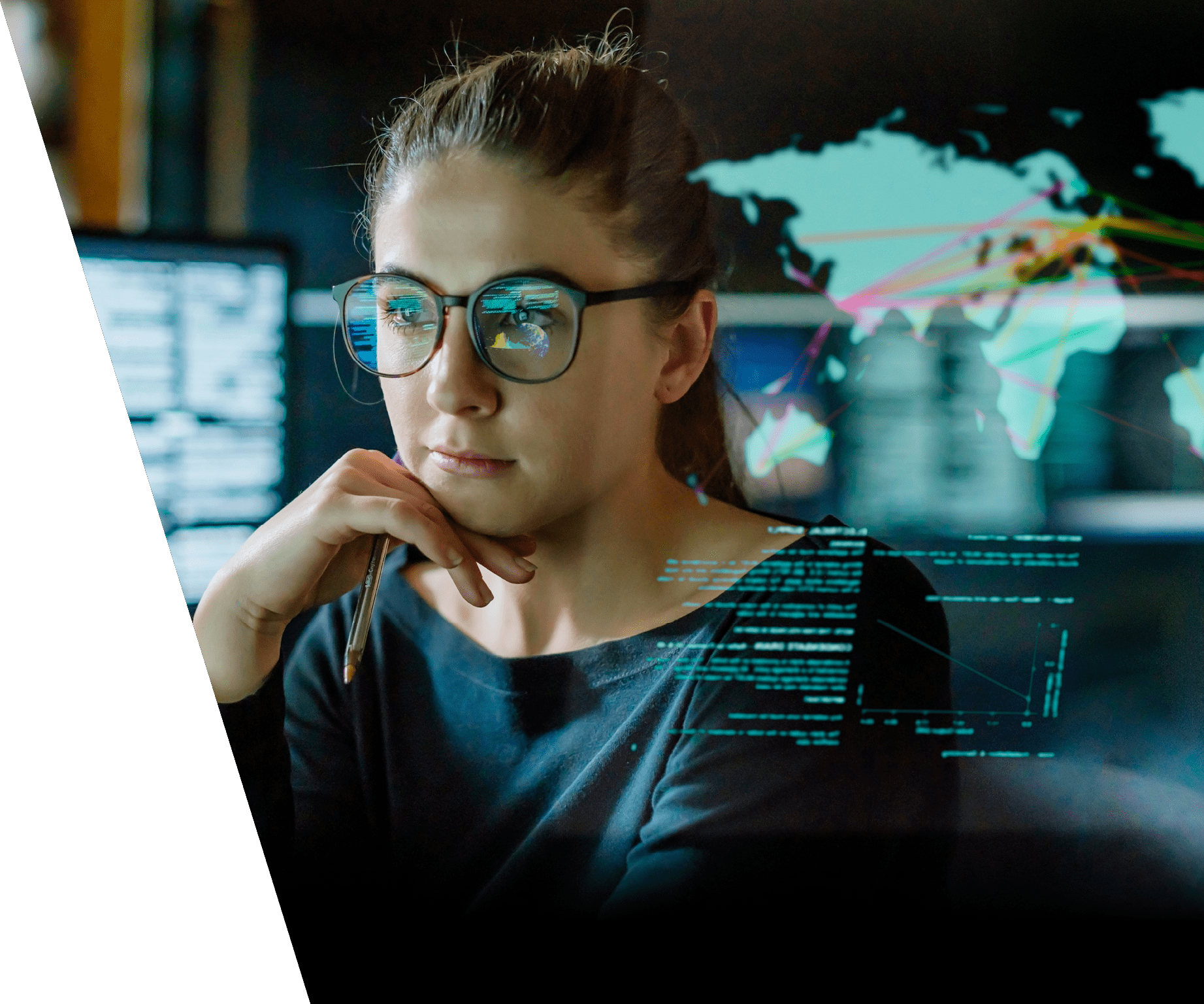 Stock image of a young woman, wearing glasses, surrounded by computer monitors in a dark office. In front of her there is a see-through displaying showing a map of the world with some data.